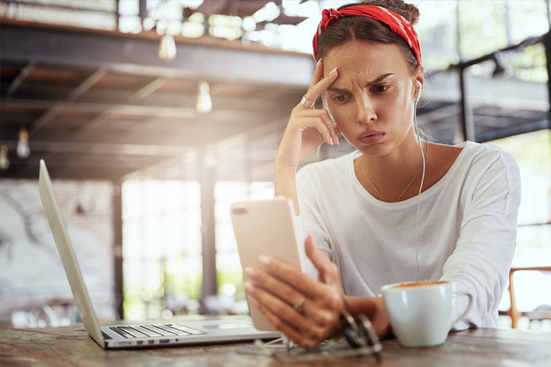 una donna che cerca di decifrare una mail dal suo dispositivo mobile