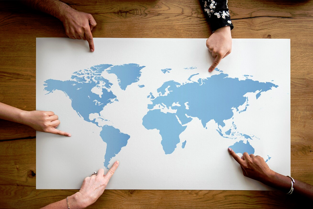foto dall'alto di una cartina geografica con persone che indicano diversi punti