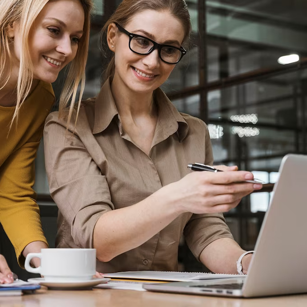 due colleghe che lavorano al pc in maniera rilassata